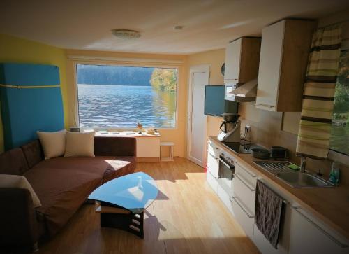 a living room with a couch and a view of the water at Hausboot MS Donautal in Neuhaus