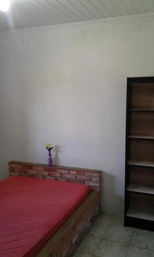 a bedroom with a bed with a red blanket at Magistério para veraneio e descanso in Pinhal