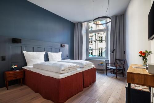 um quarto com uma cama grande e uma janela em Hotel Die Reederin em Lübeck