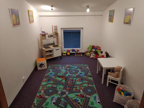 a childs room with a table and a rug at Hvězda Apartments in Harrachov