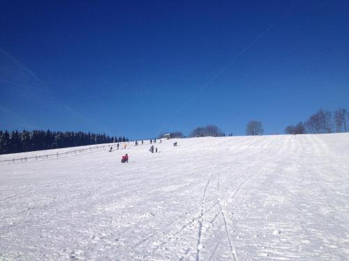 a group of people skiing down a snow covered slope at Villa Im Bongert - Tor zum Nationalpark Eifel in Hellenthal