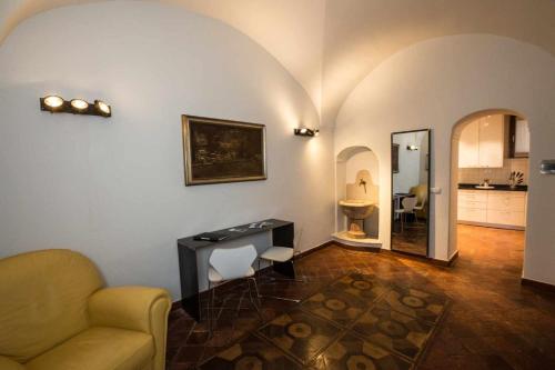 un soggiorno con scrivania e divano e una cucina di Historical apartment in the center of Gravedona - Larihome A02 a Gravedona