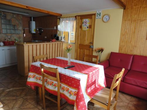 a living room with a table and a red couch at Hostal Miramar in Valparaíso