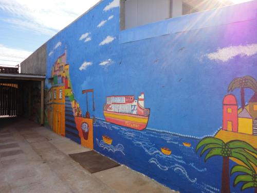 a blue wall with a mural of a city and a boat at Hostal Miramar in Valparaíso