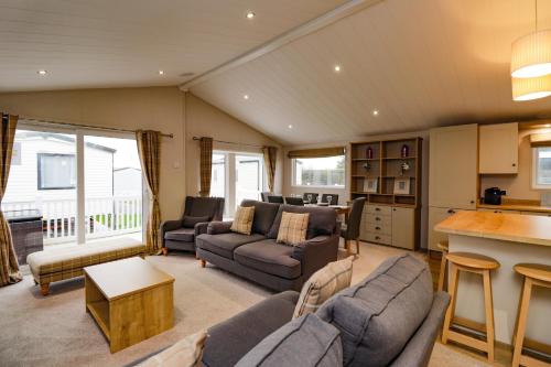 a living room with two couches and a kitchen at 2 bedroom Lodge at Pevensey Bay in Pevensey