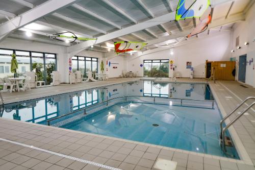 a large indoor swimming pool with blue water at 2 bedroom Lodge at Pevensey Bay in Pevensey
