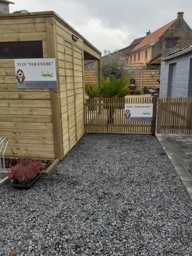 a wooden shed with a sign in a yard at "Ter Ename n°2" in Oudenaarde