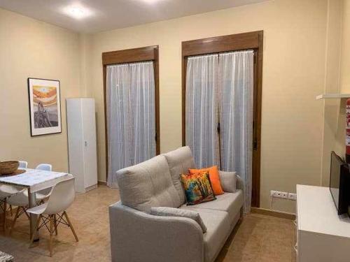 a living room with a couch and a table at Cumbres de los Picos Apartamento Treparriscos in Poo de Cabrales
