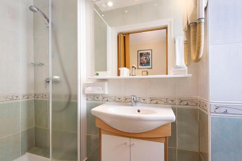 a bathroom with a sink and a shower at Hotel Terminus Lyon in Paris