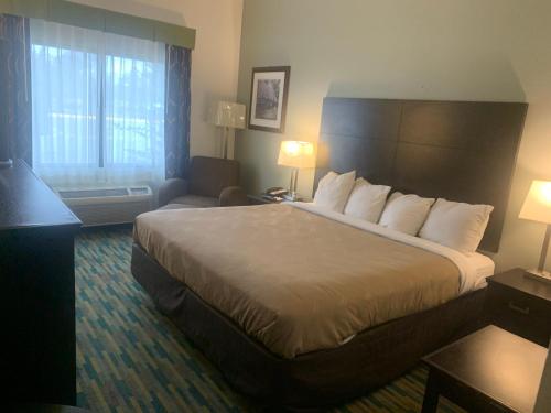 um quarto de hotel com uma cama grande e um sofá em Quality Inn Winder, GA em Winder
