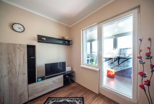 a living room with a tv and a large window at Apartment Africa in Belgrade