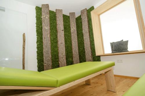 eine grüne Bank in einem Zimmer mit Fenster in der Unterkunft Weberstube Weberhaus Zollhaus Zollstöckl in Obertilliach