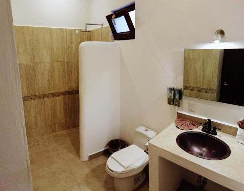 y baño con lavabo, aseo y ducha. en Hotelito Los Sueños, en Sayulita