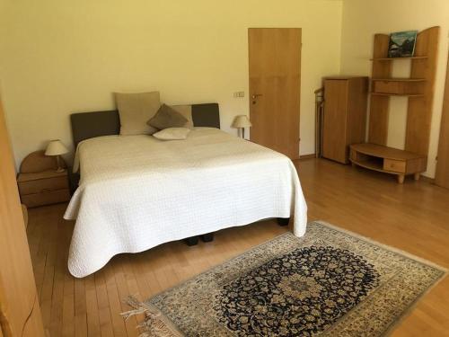 - une chambre avec un lit blanc et un tapis dans l'établissement Secret Garden, à Müllheim
