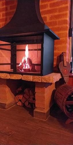 a brick fireplace with a fire in it at Chalés Descanso na Serra in Monte Verde