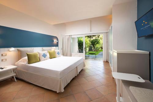 a bedroom with a large bed and a television at Chia Laguna - Hotel Village in Chia