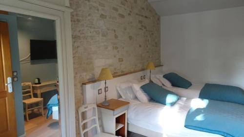 ein Schlafzimmer mit einem Bett mit blauen Kissen in der Unterkunft Campagne Océan in Montroy
