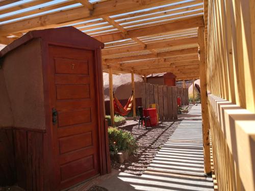 a wooden entrance to a garden with a wooden pergola at San Pedro Domos in San Pedro de Atacama