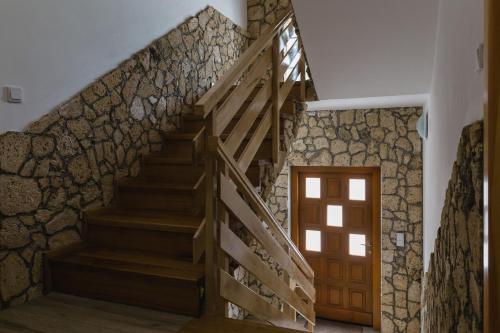 a staircase in a house with a stone wall at Rustic Lodge Plitvice in Plitvička Jezera