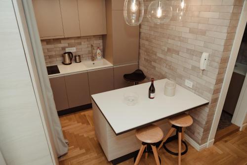 een kleine keuken met een witte tafel en twee stoelen bij Opera 1 in Subotica