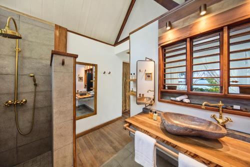 a bathroom with a sink and a shower at Constance Tsarabanjina - All Inclusive in Nosy Mitsio