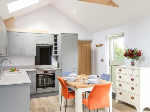 a kitchen with a table and chairs in a kitchen at The Cosy Cowshed in Axminster