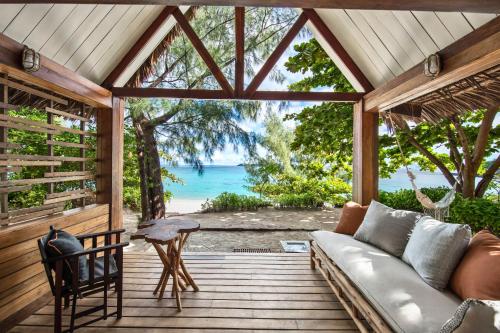 a porch with a couch and a view of the ocean at Constance Tsarabanjina - All Inclusive in Nosy Mitsio