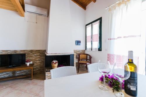 a living room with a table with two wine glasses at Residence Fior di Sulcis in Calasetta