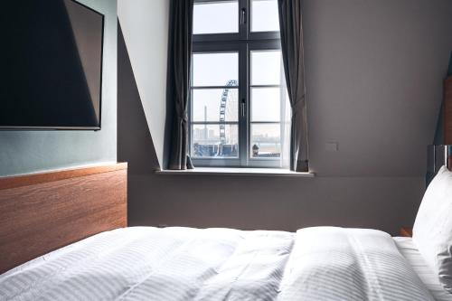a bedroom with a white bed and a window at The Wellem, in The Unbound Collection by Hyatt in Düsseldorf
