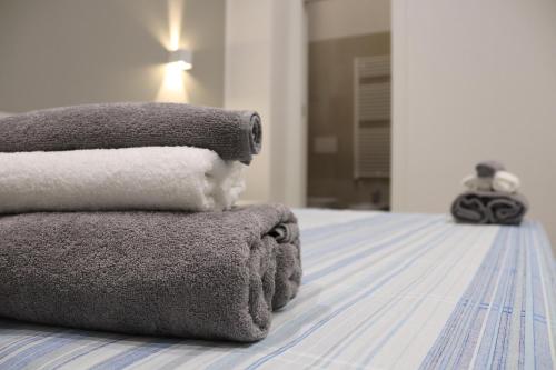 Una pila de toallas encima de una cama en Moon Bologna, en Bolonia