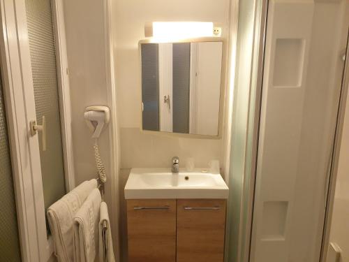 un baño con lavabo y espejo en Le Royalty, en Angers