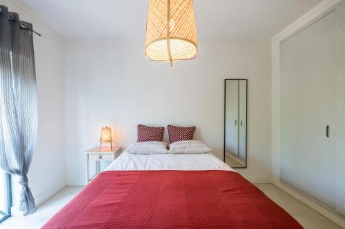 a bedroom with a large bed with a red blanket at Casa do Moinho da Praia in Altura