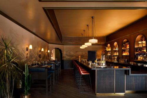 ein Restaurant mit einer Bar mit Tischen und Stühlen in der Unterkunft Life House, Lower Highlands in Denver