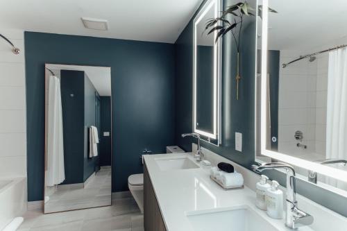 uma casa de banho com 2 lavatórios e uma parede azul em Mint House Miami - Downtown em Miami