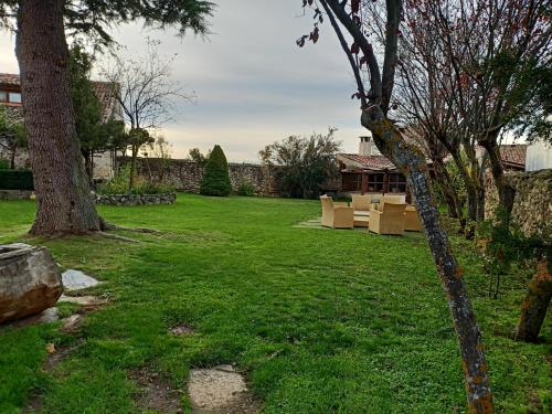 a yard with two trees and green grass at casa rural decerca in Arcones