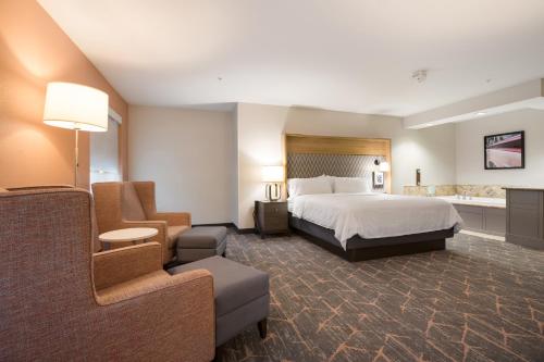 a hotel room with a bed and a bathroom at Holiday Inn Jackson NW - Airport Road, an IHG Hotel in Jackson