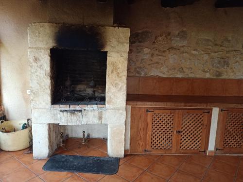 a stone fireplace in a room with a brick wall at casa rural decerca in Arcones