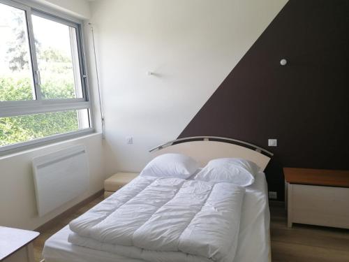 een bed in een kamer met een groot raam bij Appartement Lily-rose in Cerizay