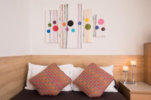 two pillows sitting on a bed in a room at Hotel De L'Horloge in Paris