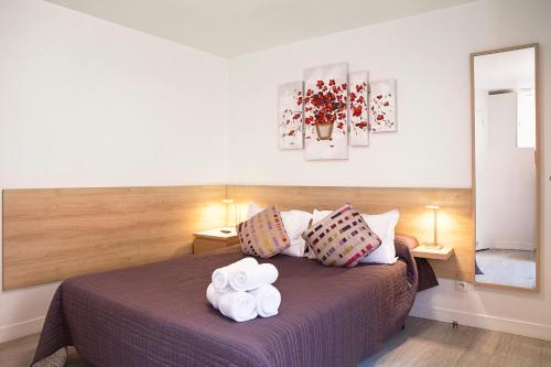 a bedroom with a bed with two towels on it at Hotel De L'Horloge in Paris