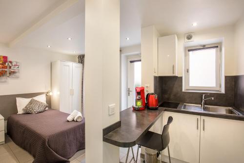 a small kitchen with a bed and a sink at Hotel De L'Horloge in Paris
