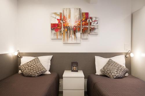 two beds sitting next to each other in a room at Hotel De L'Horloge in Paris