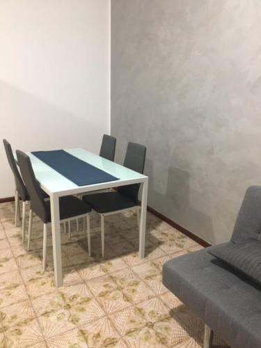 een tafel en stoelen in een kamer met een bank bij casa alla madonna di Refrancore-Asti in Refrancore