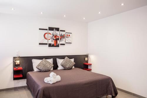 a bedroom with a bed with two towels on it at Hotel De L'Horloge in Paris