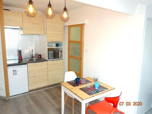 une cuisine avec une table et des chaises dans une pièce dans l'établissement Grand studio, Ramblas de Toulouse, Jean Jaurès, à Toulouse