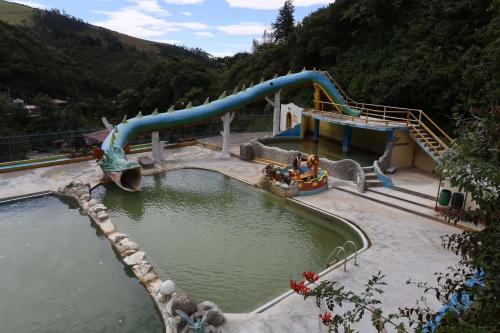 a water park with a slide in the water at Santagua Termas de Chachimbiro in Urcuquí