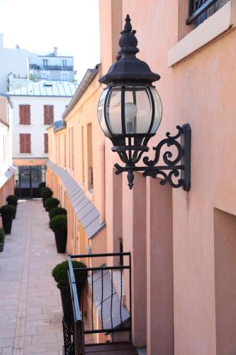 a street light attached to the side of a building at Hotel De L'Horloge in Paris