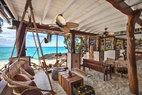 a room with a hammock and a view of the ocean at Constance Tsarabanjina - All Inclusive in Nosy Mitsio