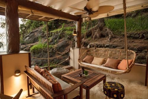 a porch with a couch and a table at Constance Tsarabanjina - All Inclusive in Nosy Mitsio