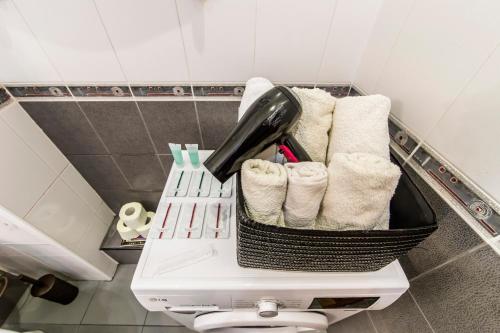einen Korb mit Handtüchern auf einem WC im Bad in der Unterkunft Затишна квартира на Майдані Незалежності in Kiew